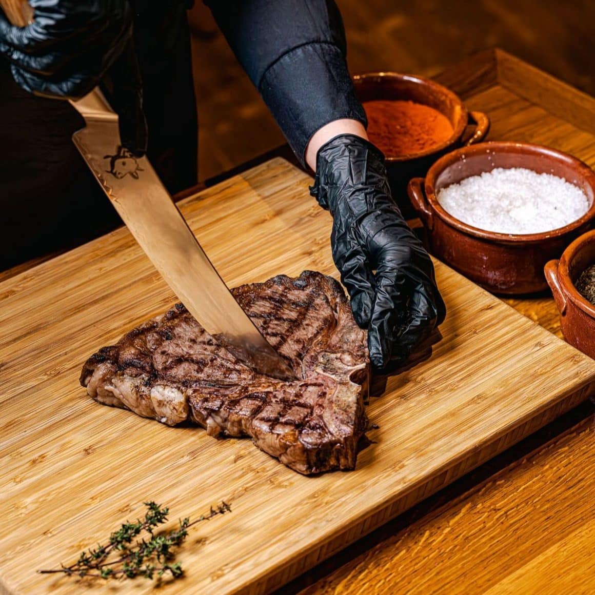 Un T-Bone steak gătit perfect, tăiat pe loc și pregătit să arate ce înseamnă cu adevărat carne premium.