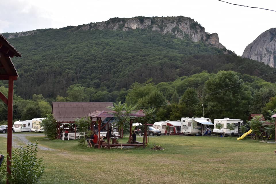 un camping dedicat pentru vacantele cu rulota, cu foișoare de lemn, este asezat la poalele unui peisaj montan 
