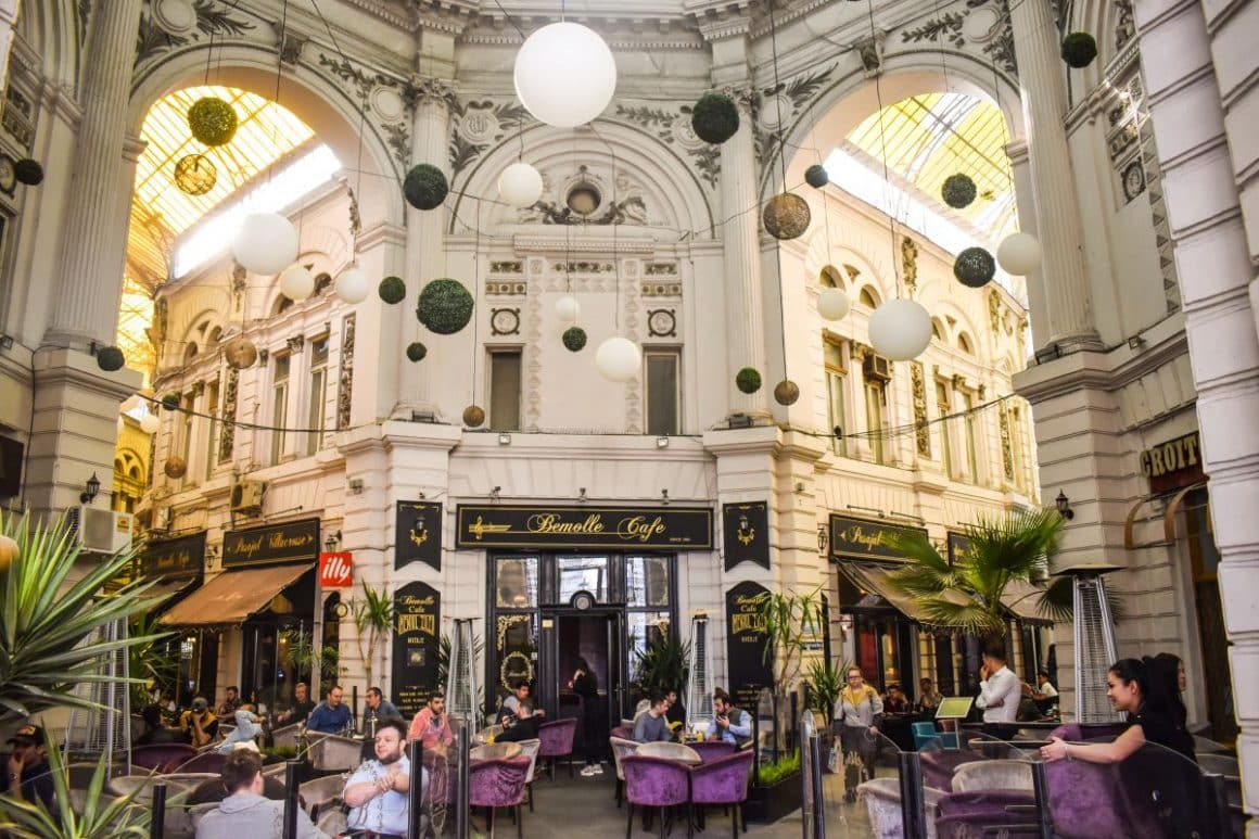 pasajul villacross din București cu un interior foarte inalt și mese și scaune asezate la terasele din interiorul pasajului. Experiențe gastronomice inedite