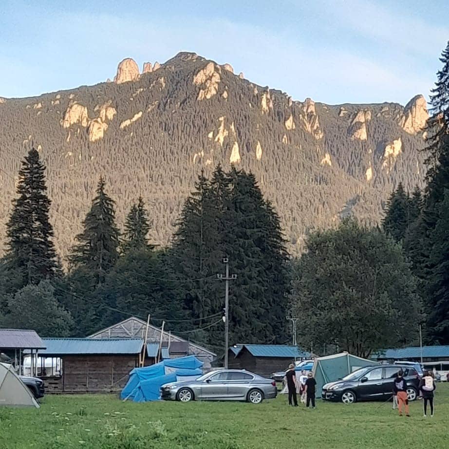 un camping dedicat pentru vacanță cu rulota, cu foișoare de lemn, este asezat la poalele unui peisaj montan, la Camping Leon Durău