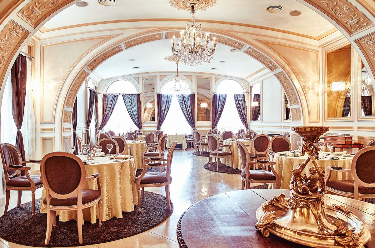 sala unuii restaurant clasic, cu mese și scaune tapițate, cantelabru și cortine impunătoare. Experiențe gastronomice inedite