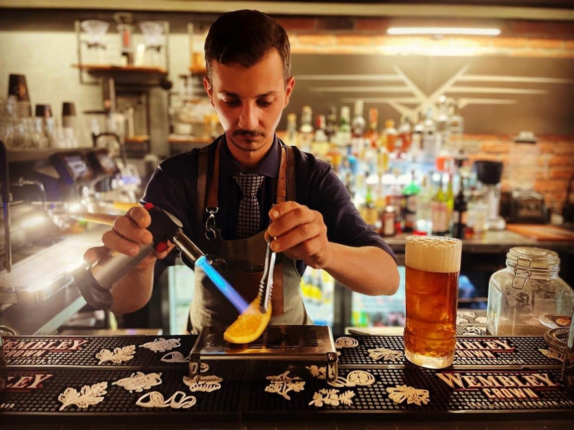 barman flambeaza o lamaie pentru a o adauga in băutură la Wings lounge cocktail barurui din București