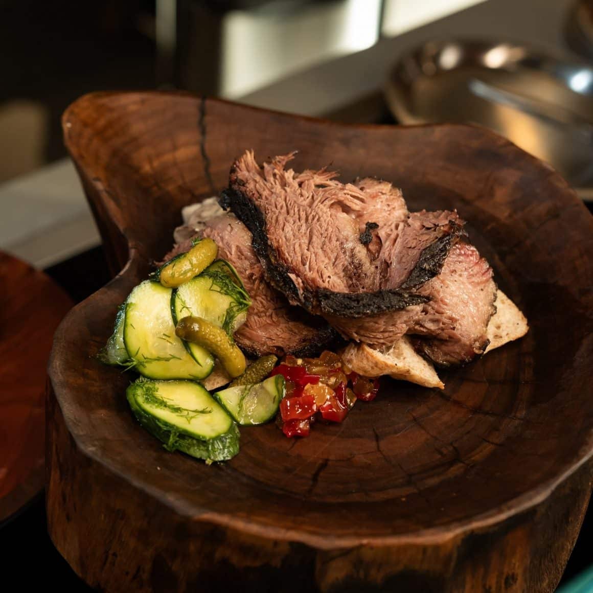 Brisket afumat, servit cu garnituri fresh și plating rustic – un mix de arome intense și prezentare autentică.