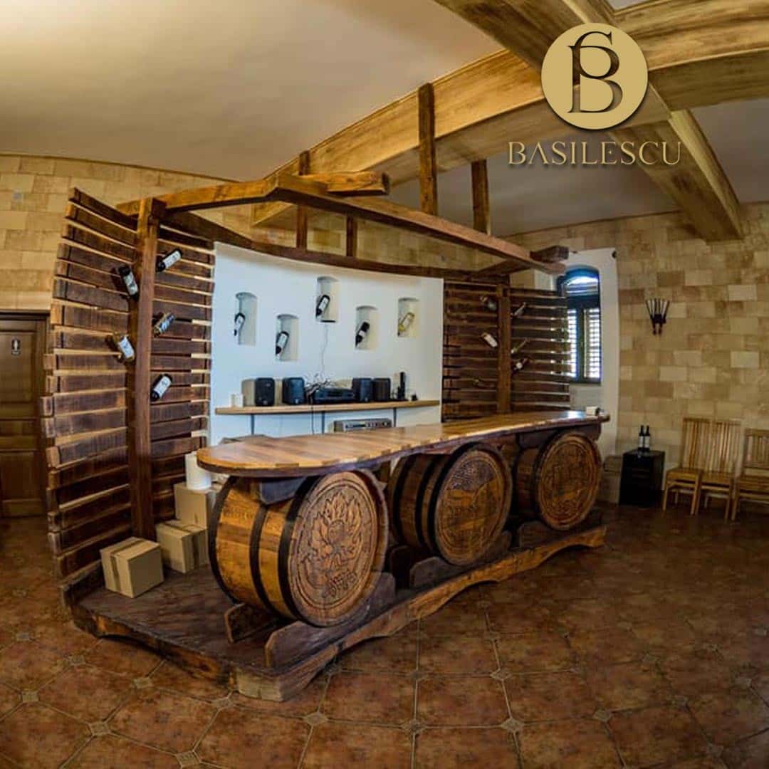 un decor de lemn cu cateva butoaie și un blat de lemn pentru degustarea vinului, intr-o cramă