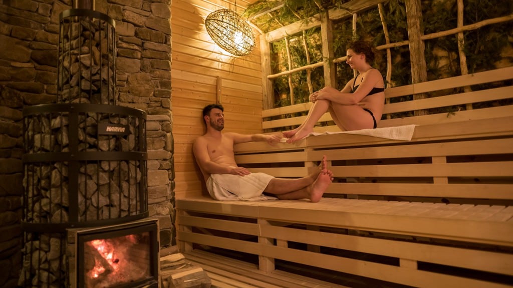 un cuplu tânăr stă de vorbă pe banchetele unei saune 