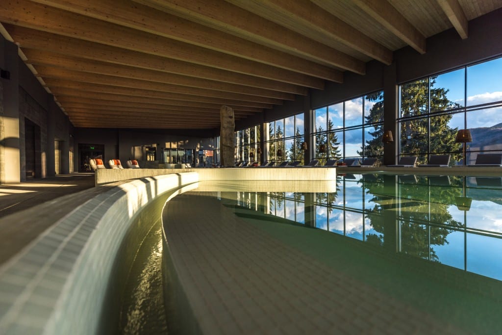 piscina cu forme sinusoidale a unui spa din românia, cu geamuri mari, pe care se văd munții. Locații spa din România, Balvanyos Resort