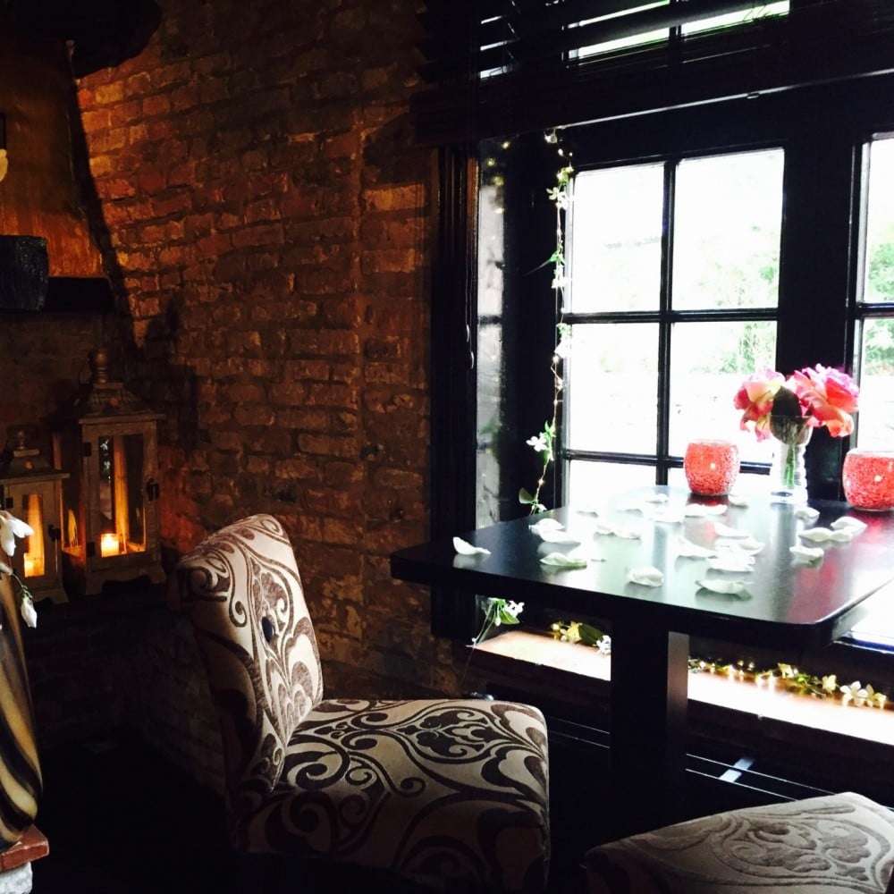Interiorul restaurantului One din Bruges, cu fotolii confortabile,  pereti din caramida si ferestre