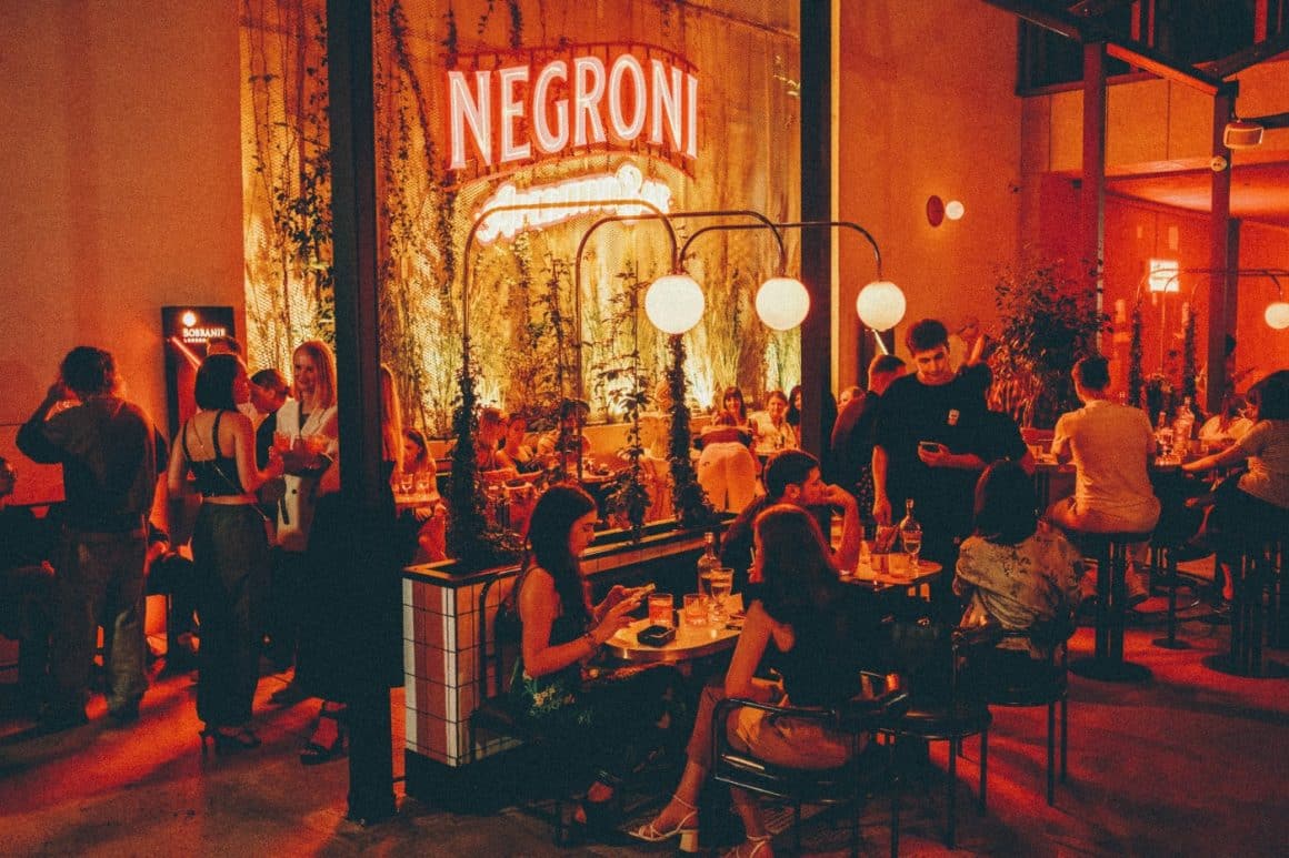 oameni asezati seara la mese in curtea de la Negroni Aperitivo Bar București