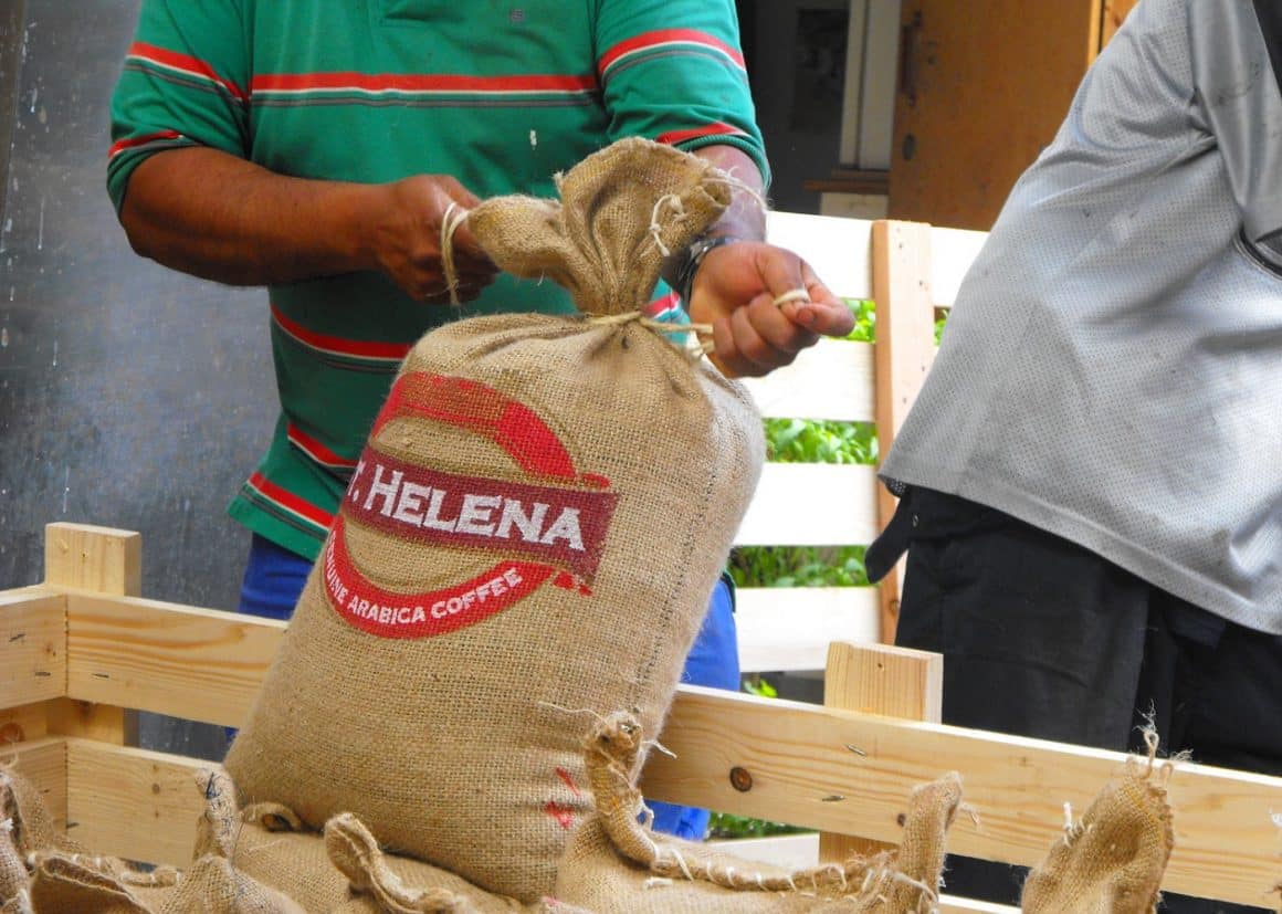 un barbat leaga la gură un sac de cafea de pe insula Saint Helena