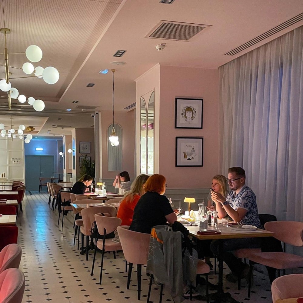 oameni iau cina intr-un cadru cu lumina difuza, la Cismigiu Bistro unul din restaurante cozy din București