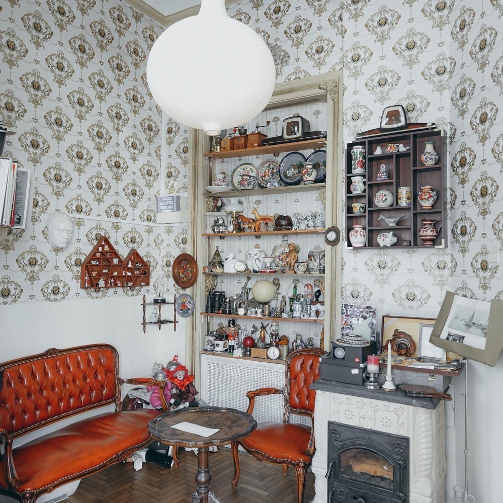 interiorul unei cafenele micute din bucuresti, cu multe elemente de deocr clasice o canapea de piele și o sobă