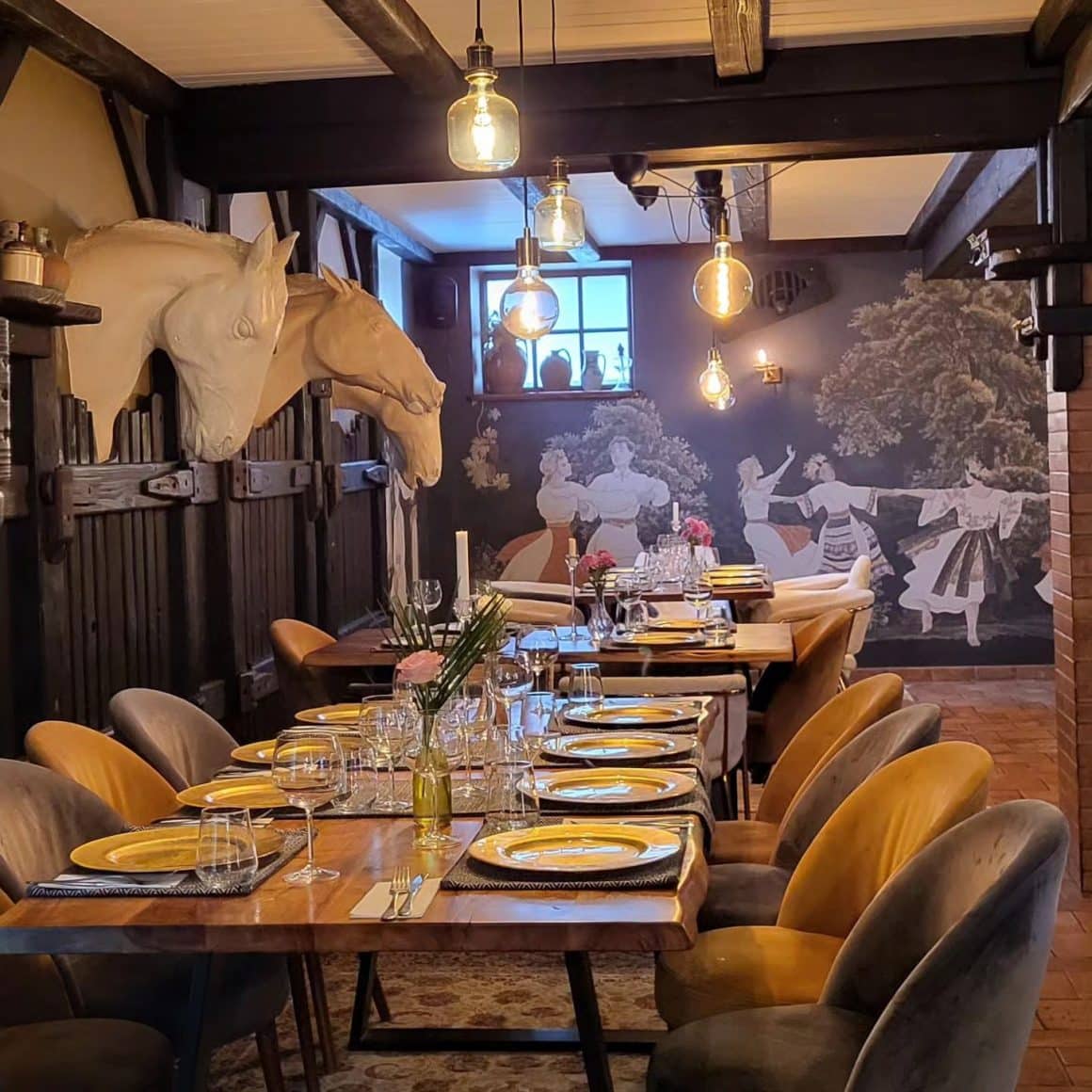 interiorul restauratului White Horse Pub & Restaurant, cu mese intinsa in dreptul carora se afla pe perete busturile unor cai stilizati