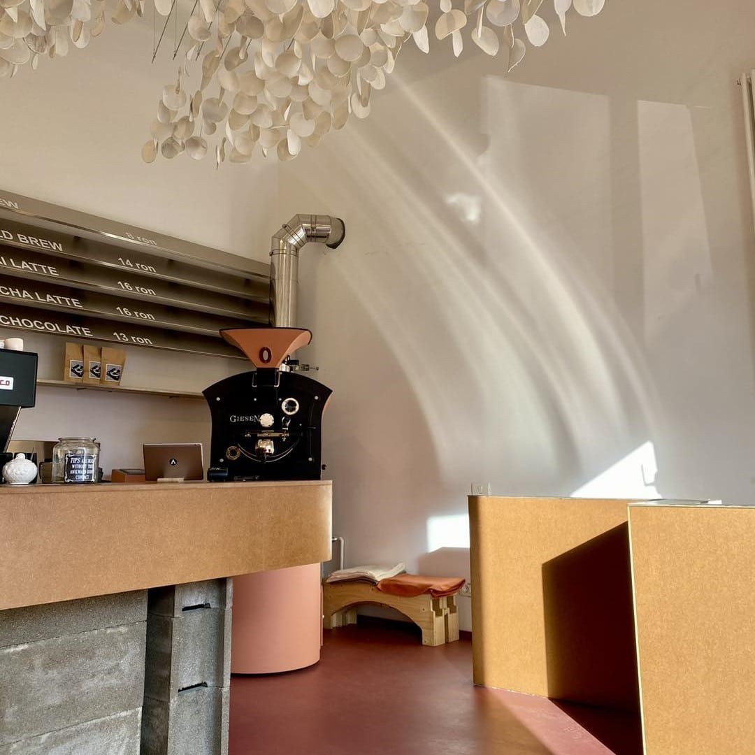 interiorul unei cafenele micuțe din bcuresti, cu barul și prăjitorul de cafea