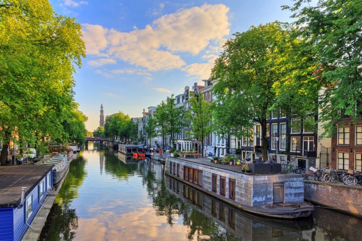 un canal cu mai multe ambarcatiuni locuibie din amsterdam