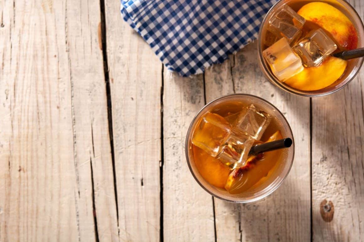 două pahare de cidru cu bourbon, fotografiate de sus, pe o masă de lemn