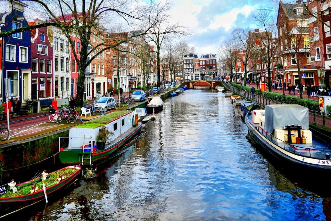 un canal cu mai multe ambarcatiuni locuibie din amsterdam