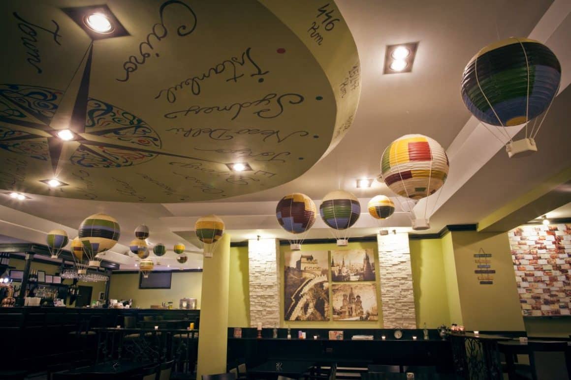 interiorul unui bar care organizează petreceri secret santa in bucuresti, cu multe baloane și o busolă imensă pe tavan