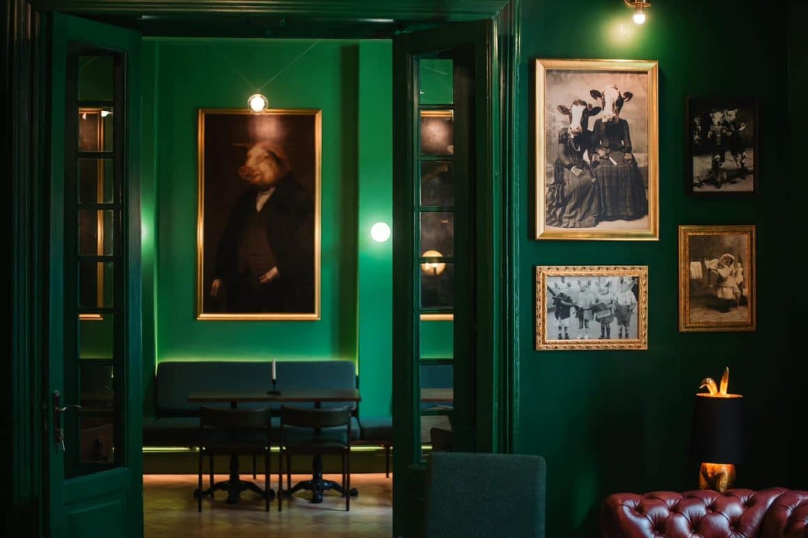 Restaurantul Animaletto House, cu pereti verde inchis, mobilier elegant su tablouri cu animale umanizate. Unul din restaurante cozy din București