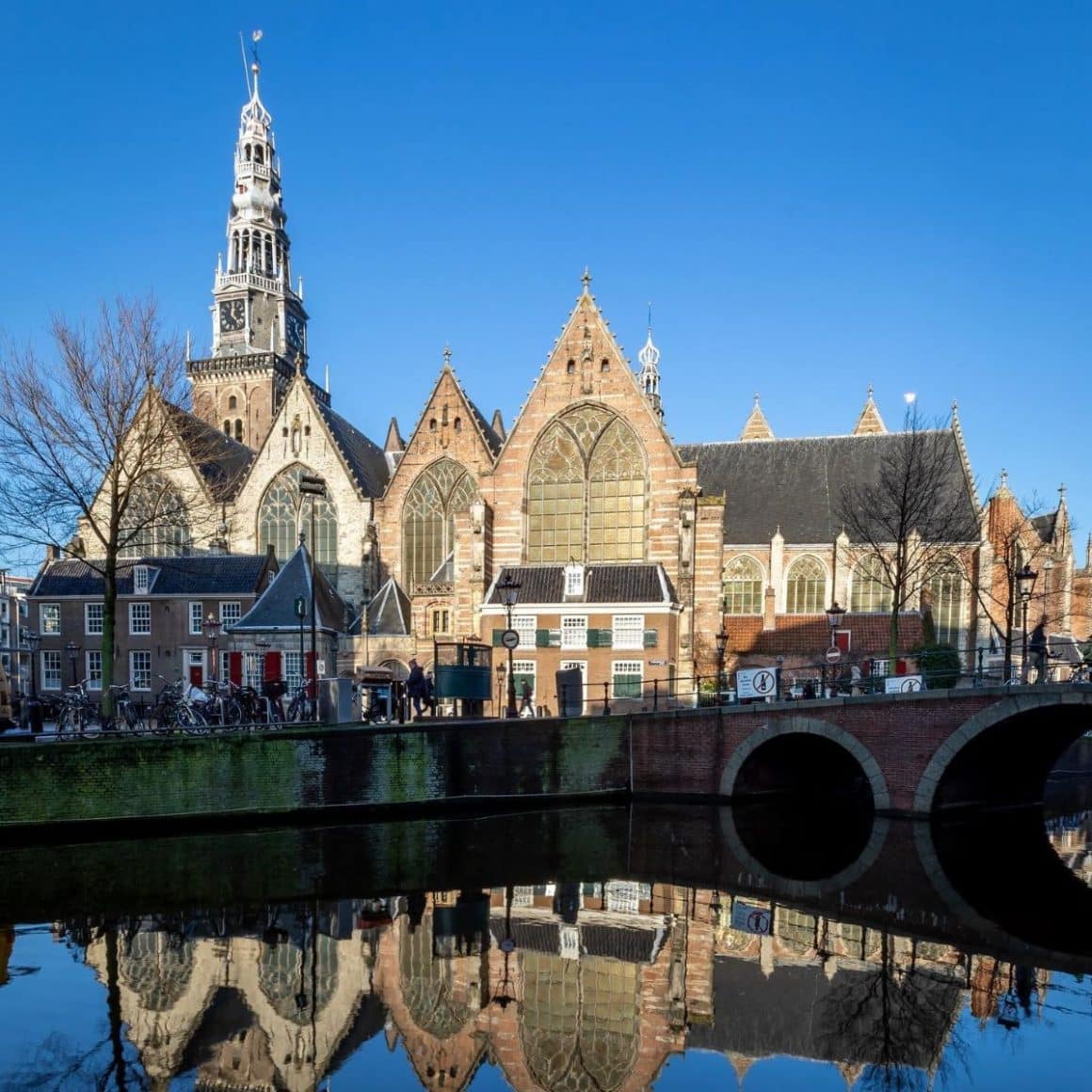 oude kerk din amsterdam, in dreptul unui canal cu poduri