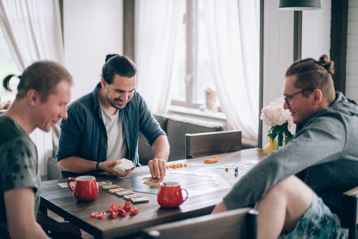 3 barbati joaca catan intr-un restaurant - locuri board games București
