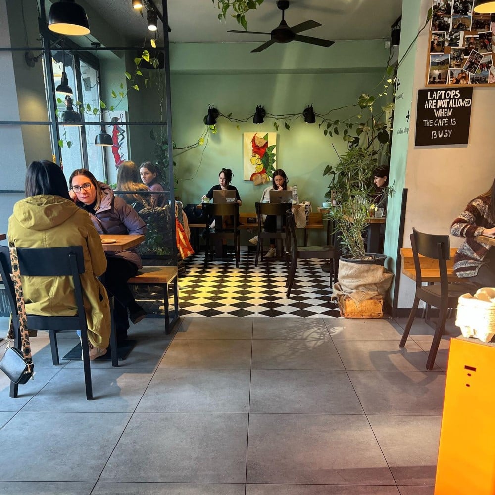 mai multi tineri socializează în interiorul unei cafenele micute din bucuresti