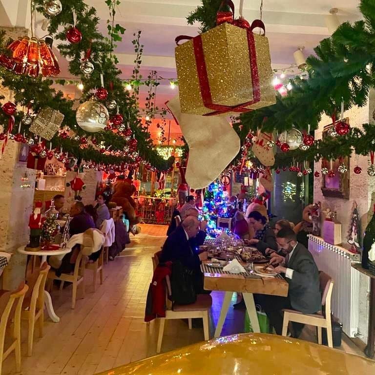 mai multe decorații de crăciun și ghirlande luminoase sunt atârnate pe tavanul restaurantului Bocca Lupo