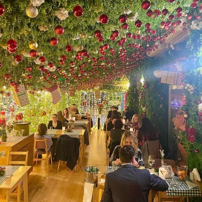 mai multe decorații de crăciun și ghirlande luminoase sunt atârnate pe tavanul restaurantului Bocca Lupo
