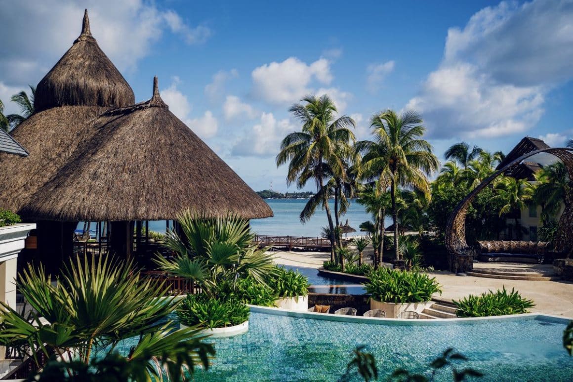 un peisaj exotic cu mai multe piscine, palmieri, și oceanul în fundal in Mauritius. destinații exotice de Revelion