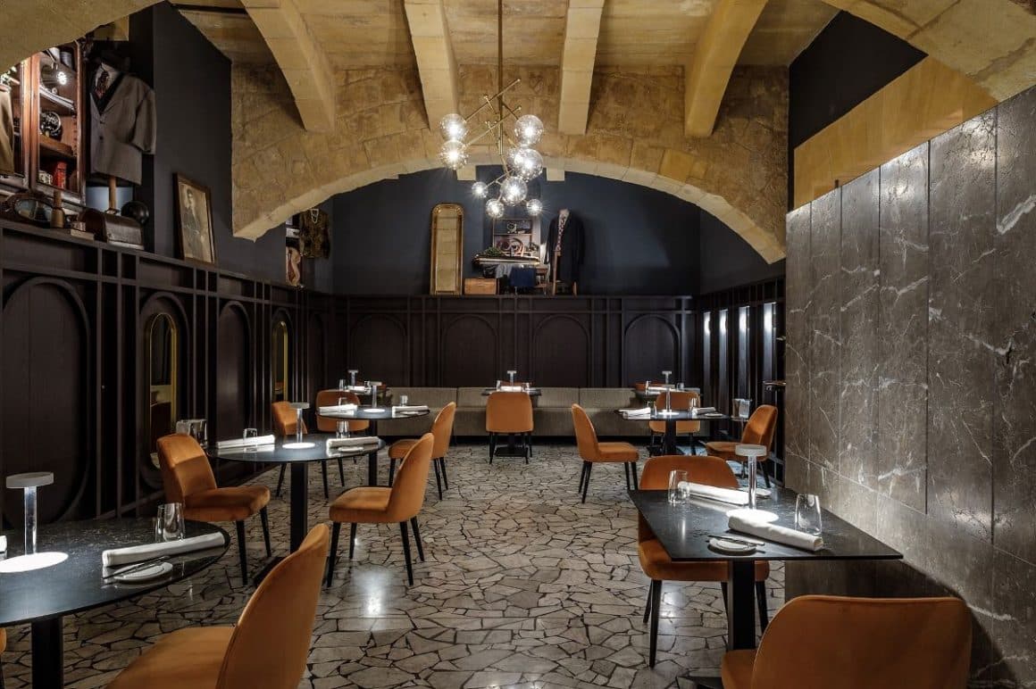 interiorul unui restaurant, cu scaune maro, pereți gri și multe corpuri de iluminat suspendate