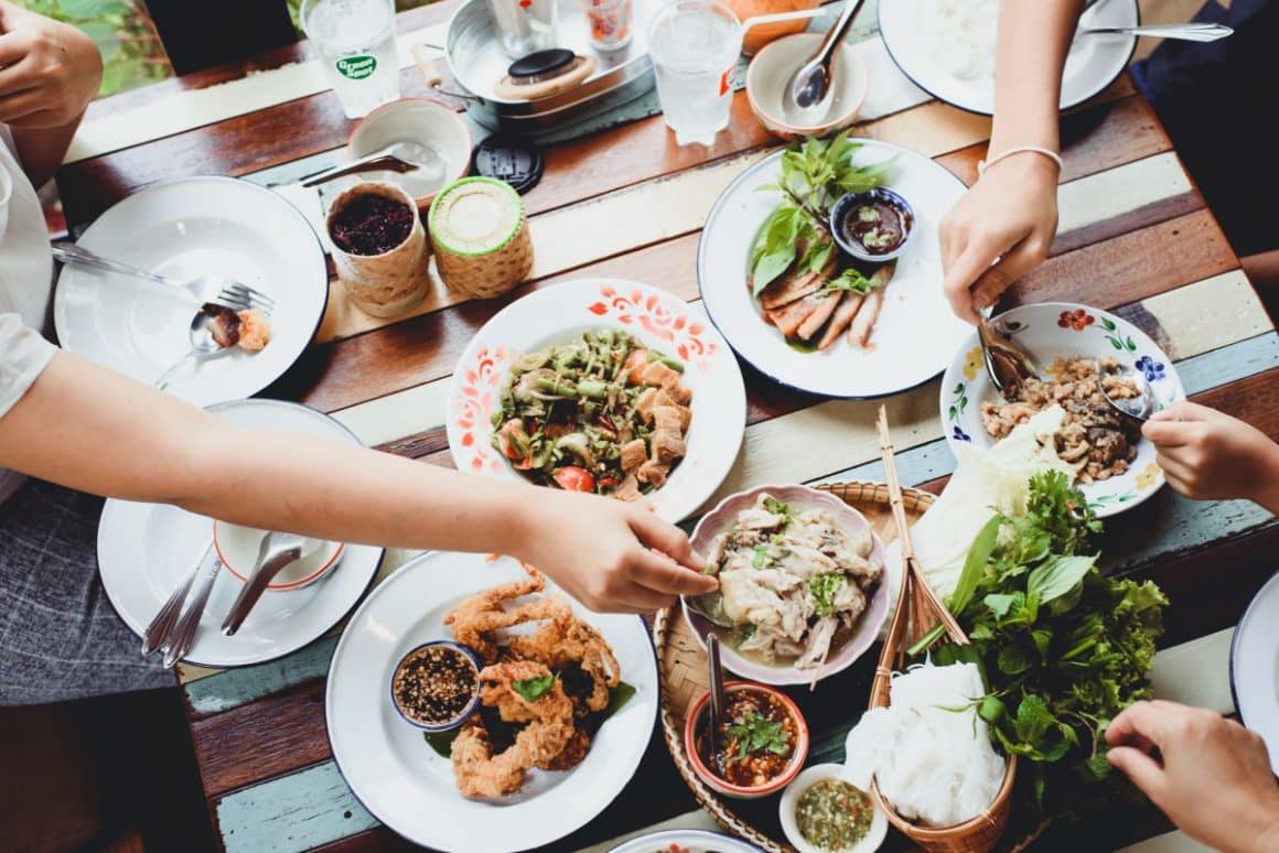 mai mulți tineri impart diferite preparate din bucătăria thailandeză