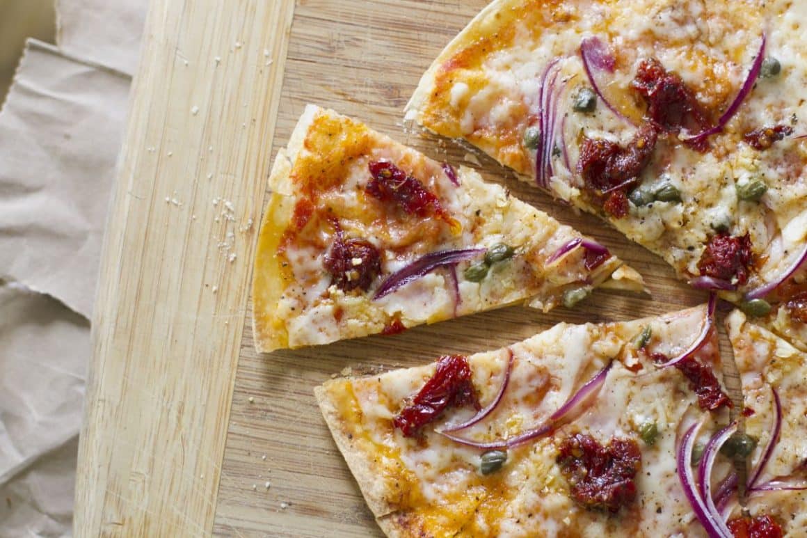 o felie dintr-o pizza crocantă este asezată pe un tocător de bucătărie. Ce poți face cu tortilla