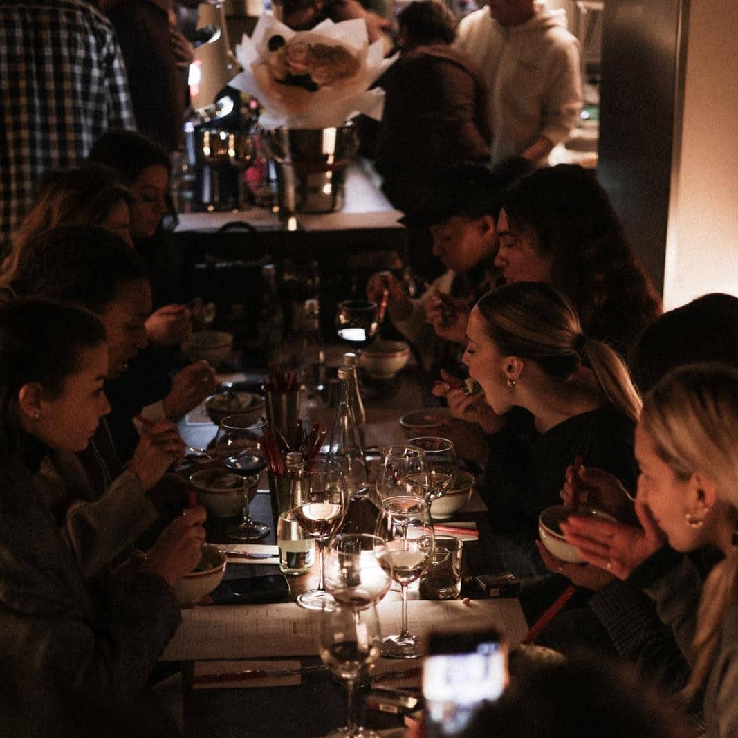 A Côté, bistro în București cu mese comune, preparate savurate alături de prieteni și atmosferă intimă, în lumina caldă a serii.