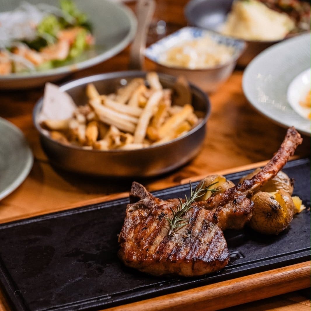 Cotlet de porc rumenit, servit cu cartofi copți și rozmarin, la Brera Bistro.
