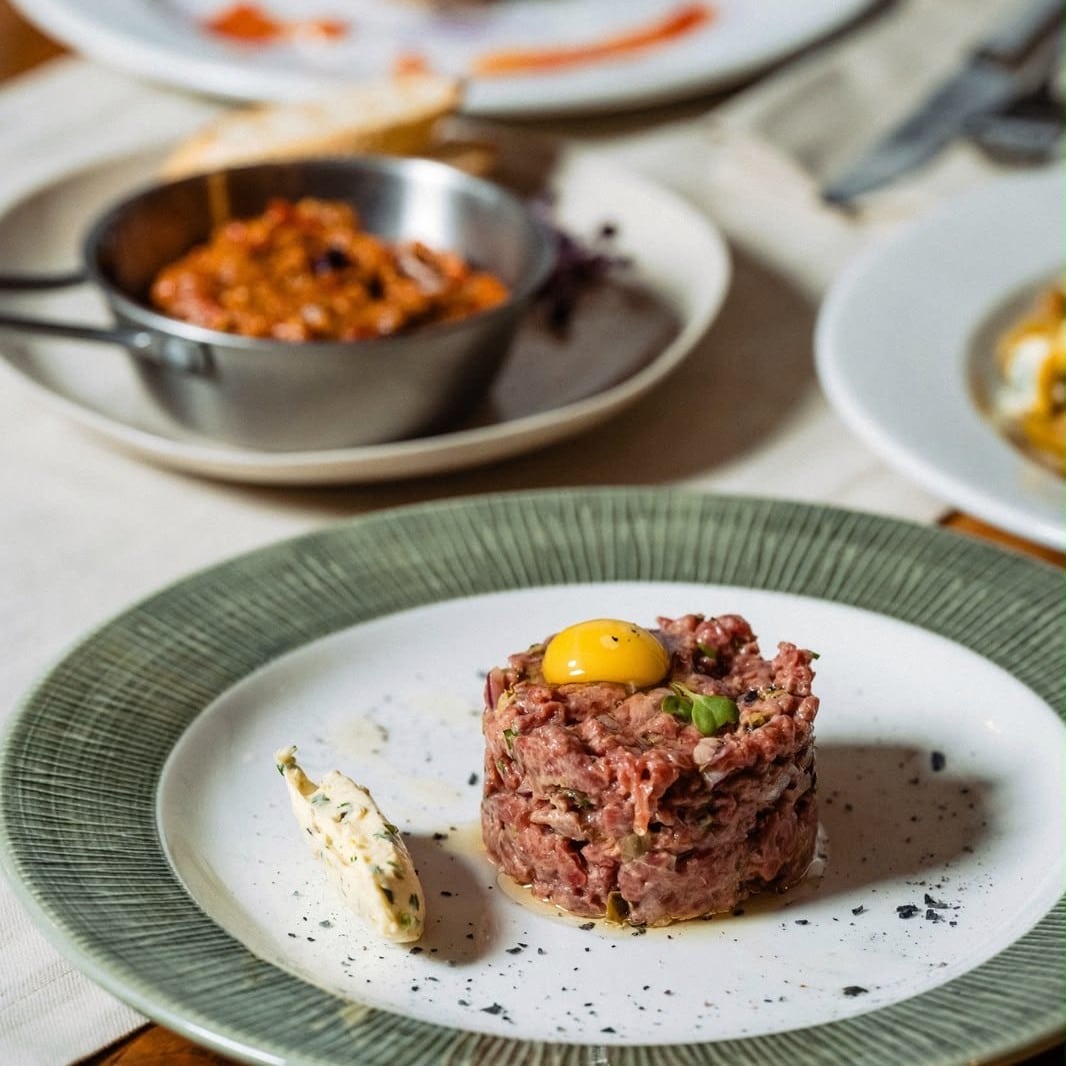 Tartar de vită cu gălbenuș de ou și unt aromat, servit la Brera Bistro din București.