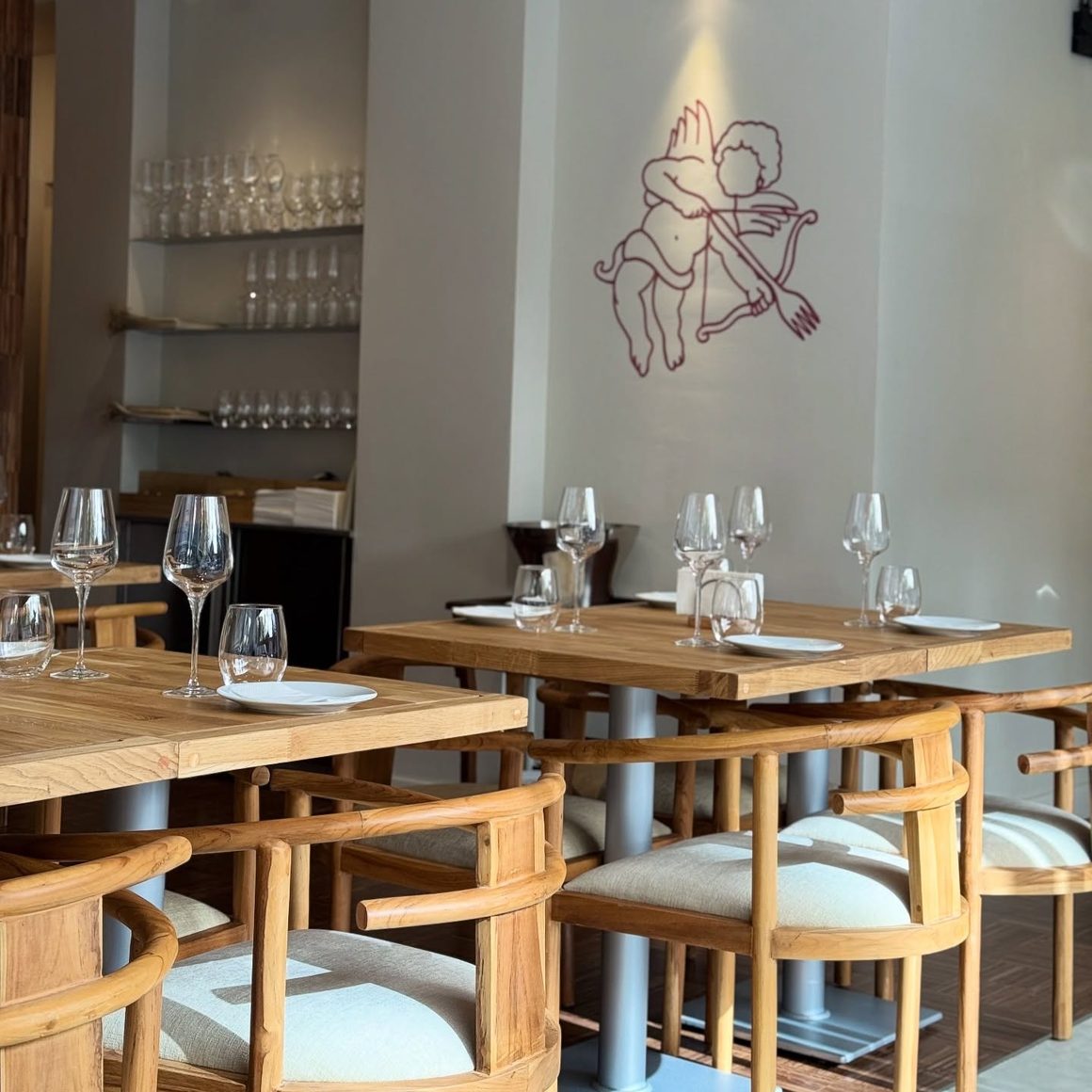 Cambun Restaurant, interior cu mese din lemn, pahare de vin și design minimalist, într-un spațiu cu atmosferă intimă.