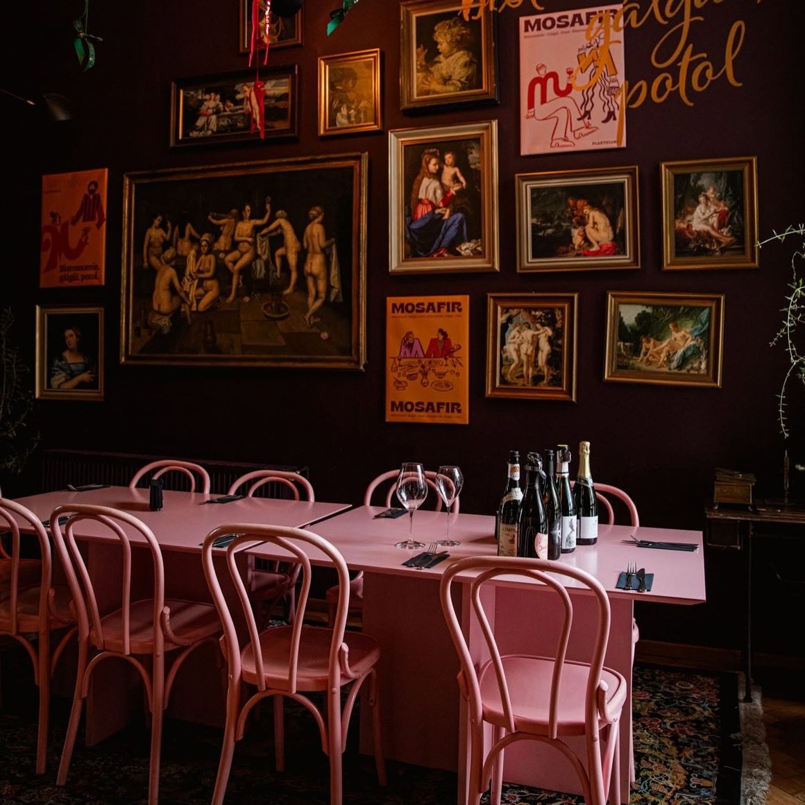 Mosafir, bistro cu design eclectic în București, cu mese roz, pereți burgundy și o colecție de tablouri care completează decorul intim.