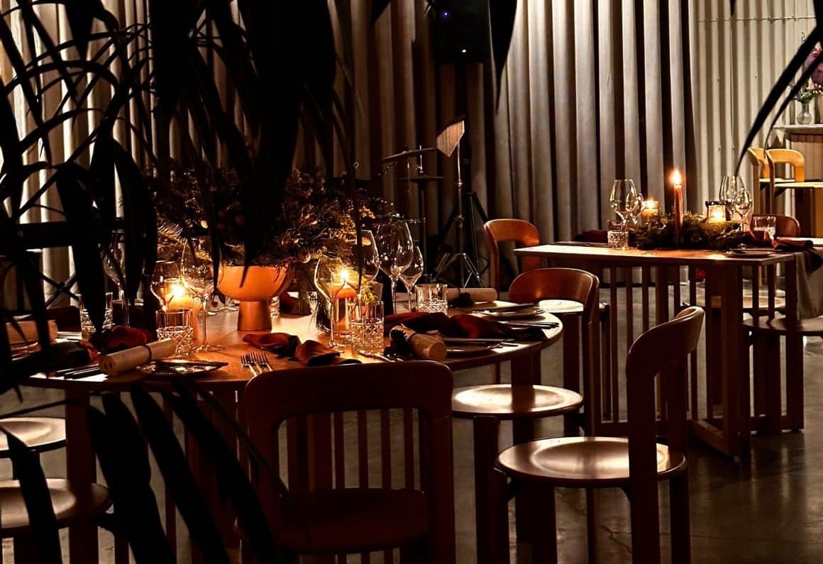Masa eleganta, la lumina lumânărilor, aranjată pentru o cină-experiență la Hambar Singureni Manor