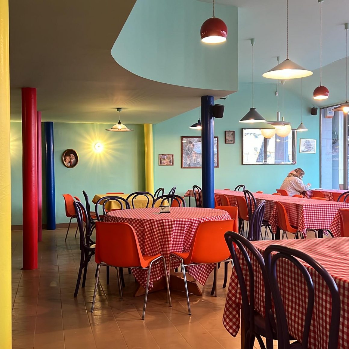 imagine din restaurant balls, cu pereti bleo, scaune rosii si fete de masa rosii