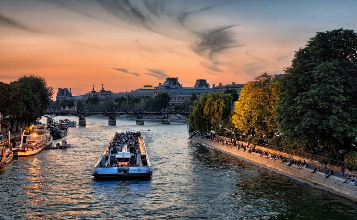 feribot cu turisti se plimba pe Sena la apus, in Paris. Unul din cele mai romantice locuri din Paris.