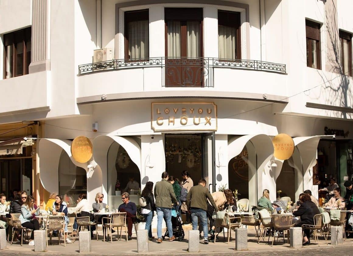 Cofetaria Love Ypu Choux, fotografiata de la distanta, cu oameni care iau masa pe terasa. Restaurante 1 martie