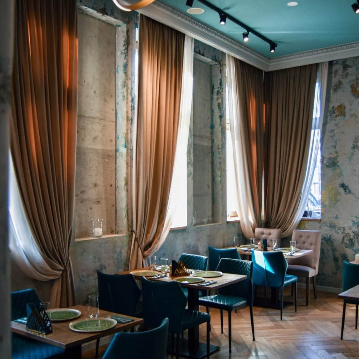 imagine din restaurant Noeme, fotografiat in penumbra, cu geamuri acoperite de draperii. Restaurante unde sa mergi la prima întâlnire