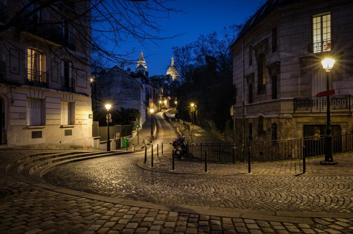 Straduta pavata din cartierul Montmartre, fotografiata seara, cu luminile aprinse in case si pe strada. Unul din cele mai romantice locuri din Paris.