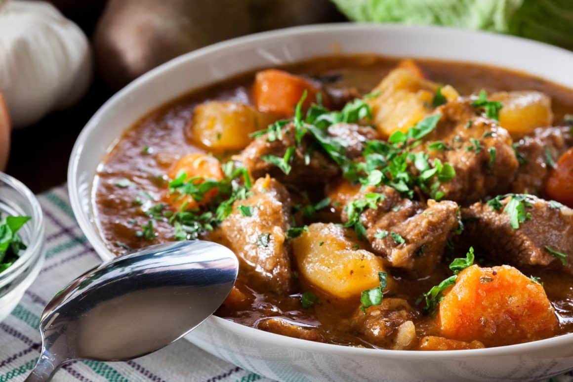 Irish stew close up, tocanita cu cu carne de oaie, cartofi, morcovi si verdeata. Mâncare irlandeză