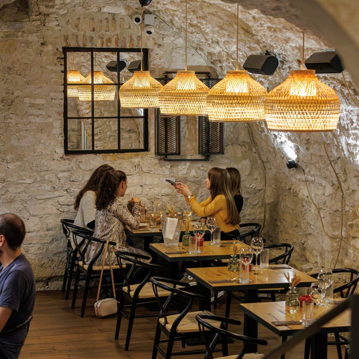 grup de 4 fete ia masa la restaurant Nativ din Cluj, amenajat elegant, cu pereti neslefuiti si corpuri de iluminat moderne