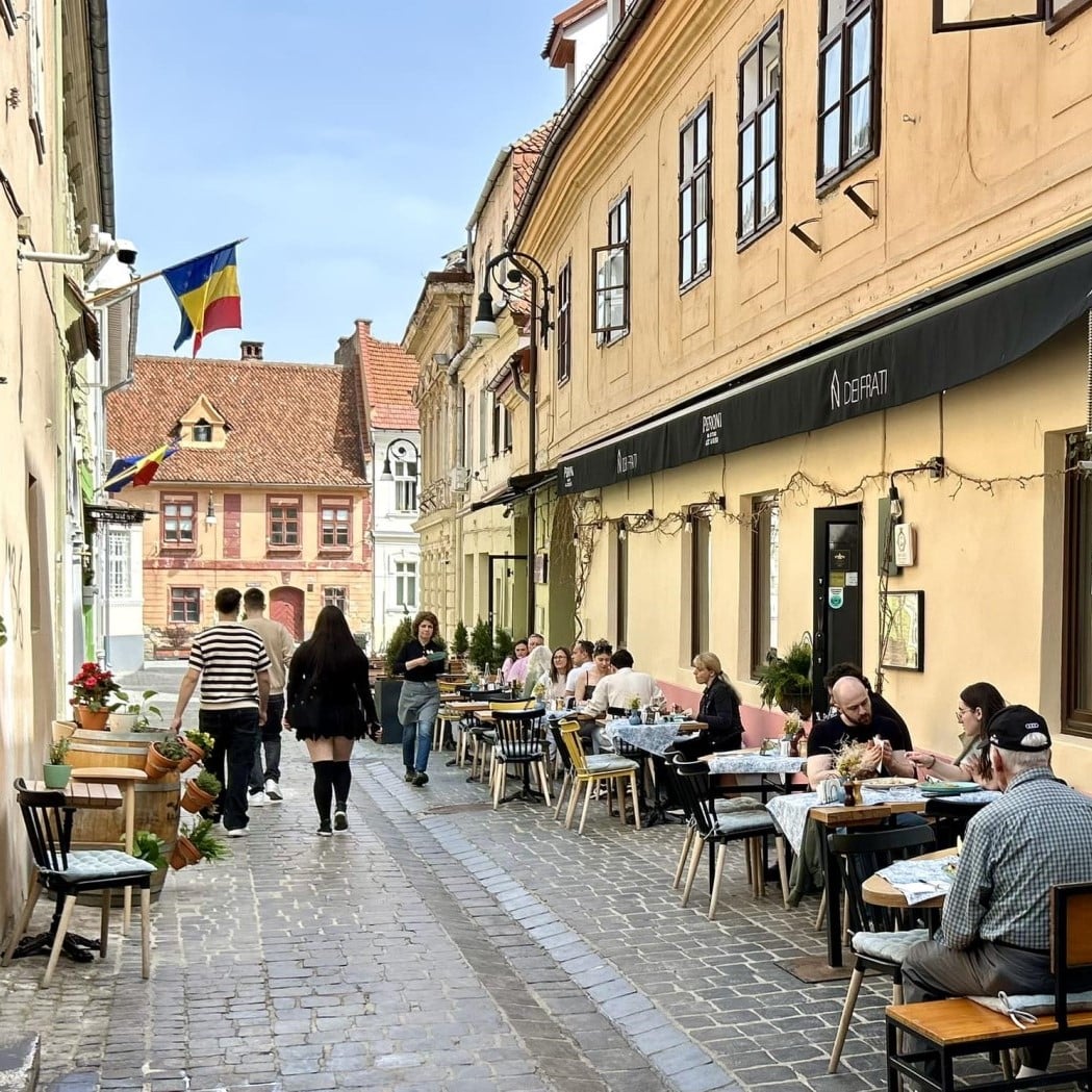 mai multi clienti iau masa pe terasa la restaurantre Dei frati din Brașov