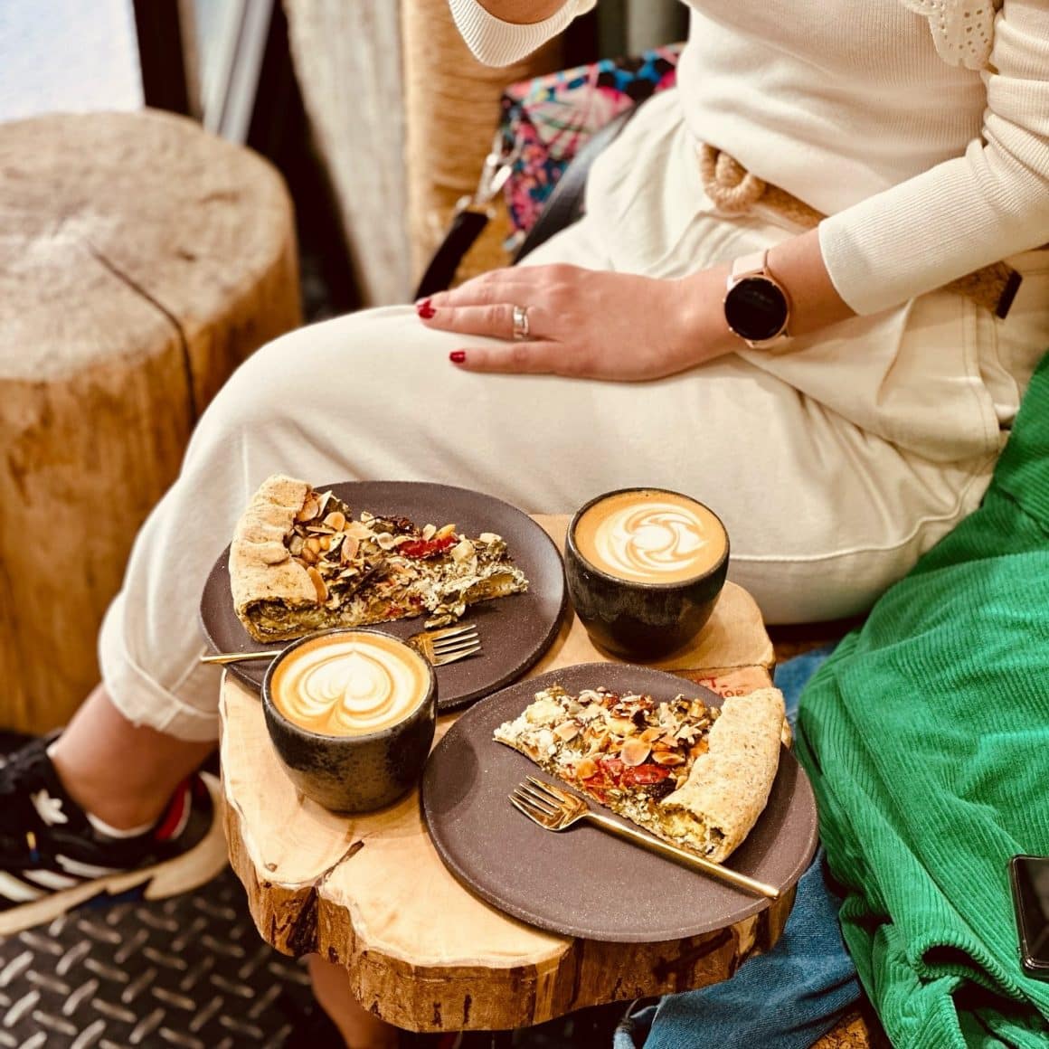 2 cesti de cafea si 2 farfurii cu quiche in dreptul unei femei la VanFructe cafenele București