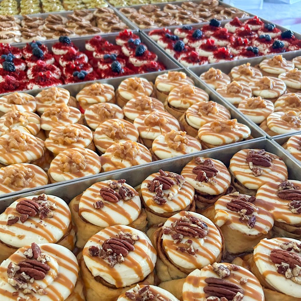 Cinnamon rolls de la Love at First Bite, cu cremă de brânză, caramel și nuci pecan, proaspăt scoase din tavă.