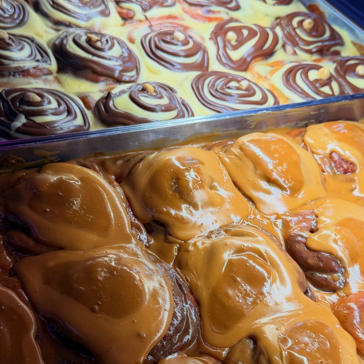 Cinnamon rolls cu glazură de vanilie și spirale de ciocolată, proaspăt pregătite la House of Cravings, în București.