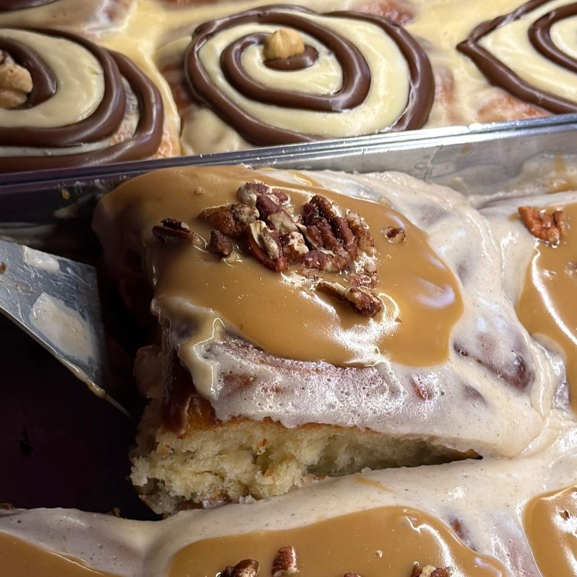 Cinnamon roll cu caramel, cremă fină și nuci pecan, surprins în prim-plan la House of Cravings din București.