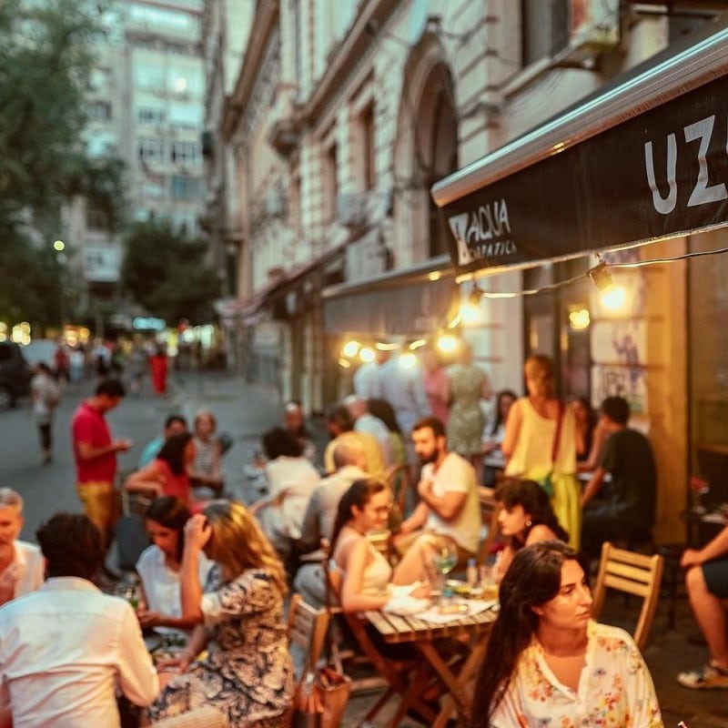 mai multi oameni seara, pe terasa la Uzina, cafenea cu cafea de specialitate. cafenele București